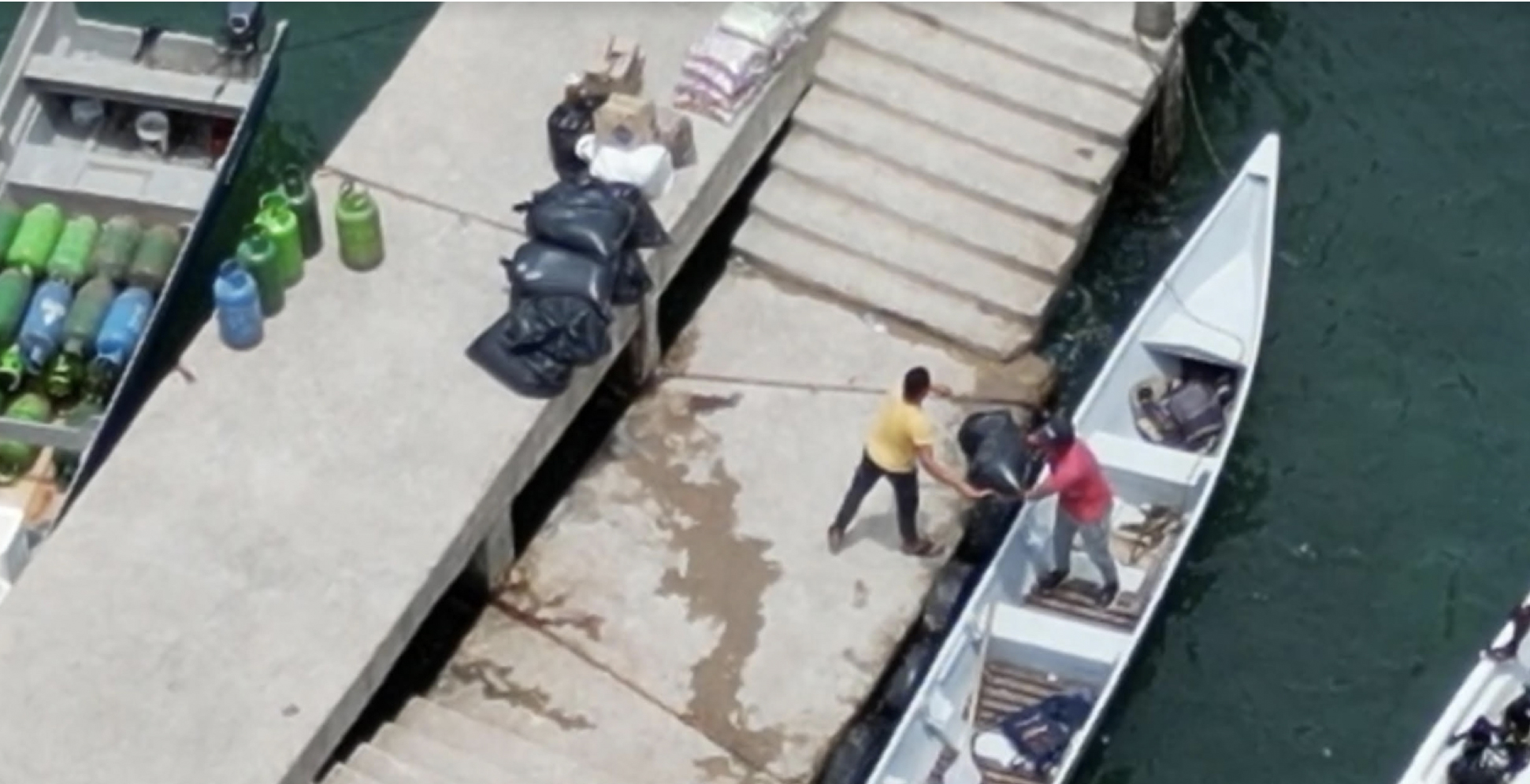 Gaitanista workers load dry bags in Capurgana for a short trip to another landing zone where immigrants will claim them