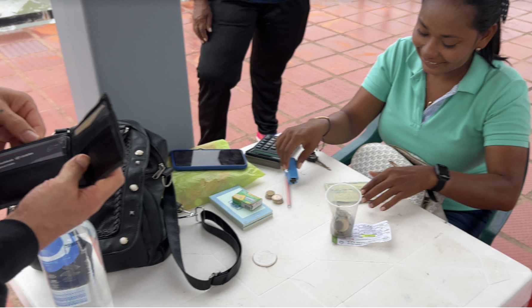 A City of Necocli tax collector takes money from immigrants at the boat dock as a condition of departure across the Gulf of Uraba